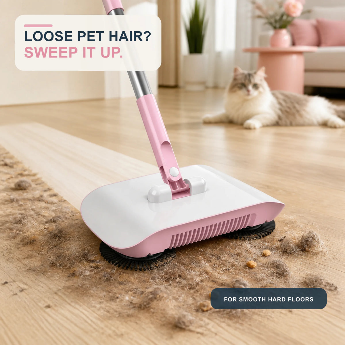 Blush Pink manual sweeper crossing loose pet hair on hard flooring with a cat in the background