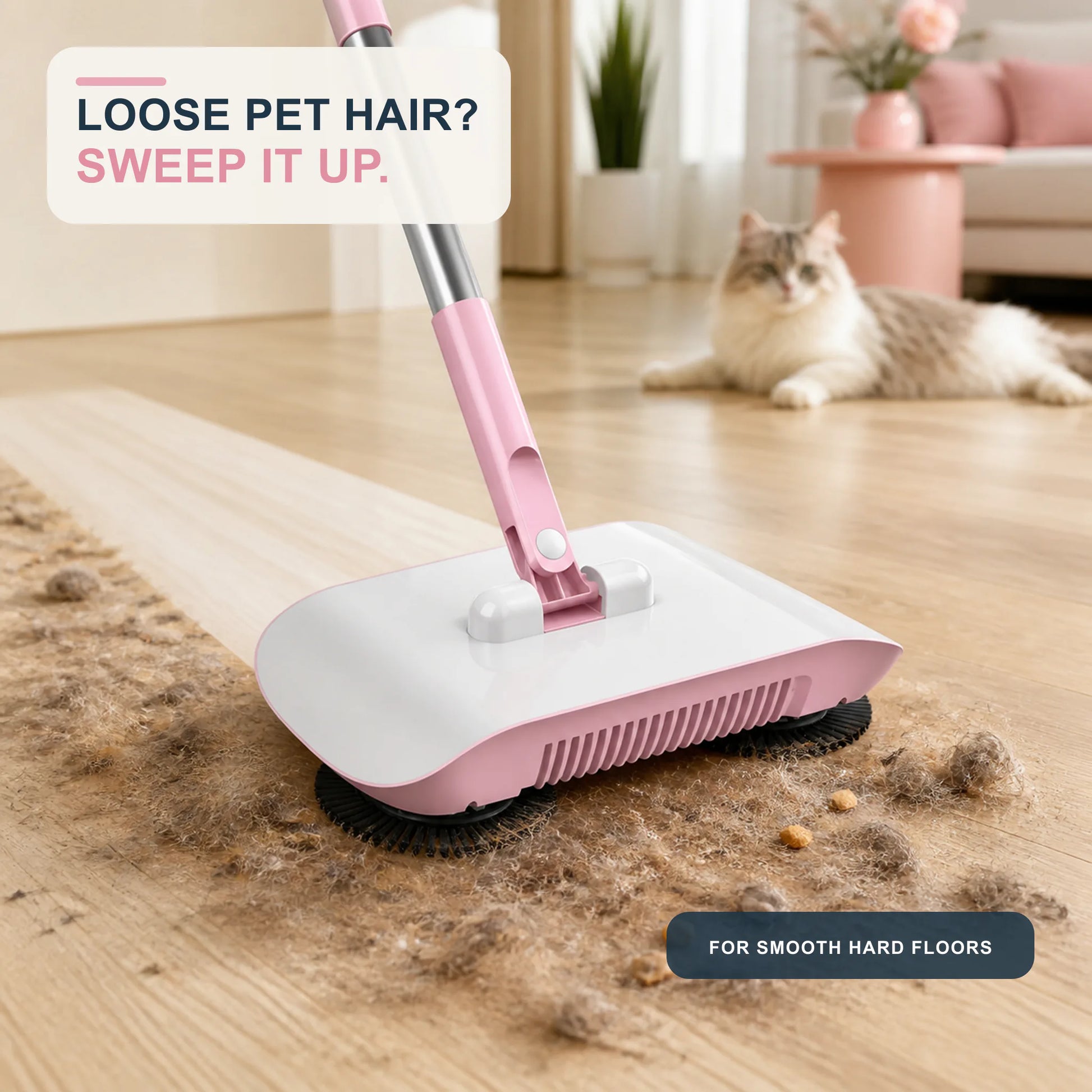 Blush Pink manual sweeper crossing loose pet hair on hard flooring with a cat in the background